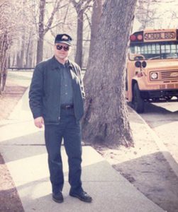 Mike standing in front of a school bus when he was a bus driver
